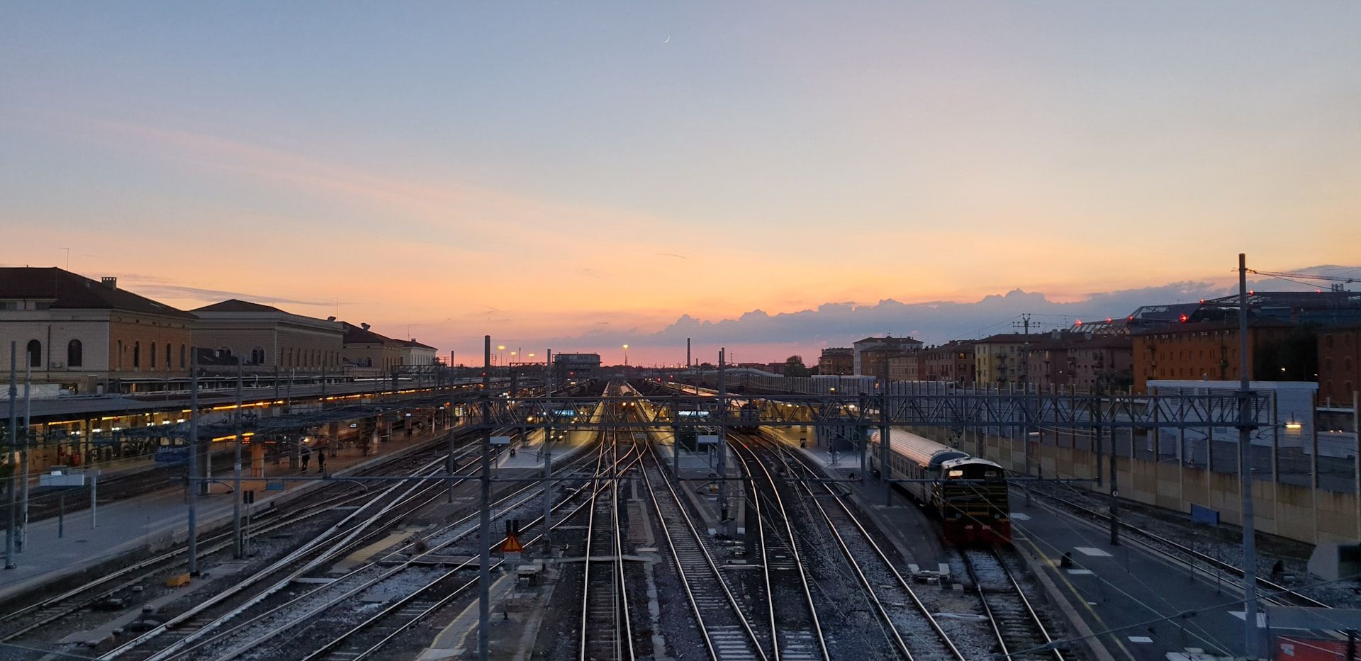 Bangård med järnvägsspår i solnedgång